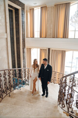 The bride and groom are on a beautiful staircase.
