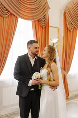 The bride and groom are in the lobby of the Wedding Palace. 