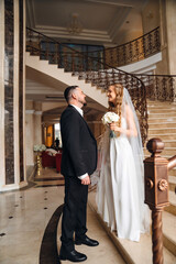 The bride and groom are on a beautiful staircase.