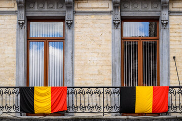 Belgian flags draped over the railing of decorative iron balcony in Brussels, Belgium