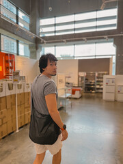 Asian relaxed young man is depicted in a sleek, modern interior space that is stylish and trendy