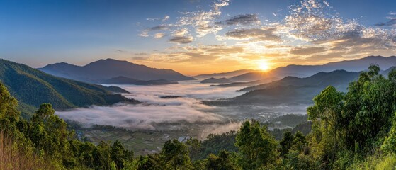 Panoramic view of a valley filled with mist at sunrise, surrounded by mountains and lush green trees under a partly cloudy sky