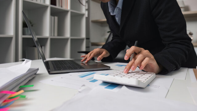 Financial Analysis. Professional accountant calculating data with laptop and calculator.