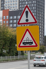 Road signs about an intersection with tram traffic on an autumn day