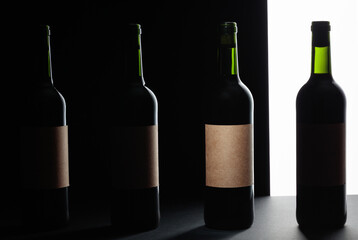 Red wine bottles silhouette over black background.