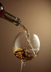 Pouring white wine from a bottle into a glass.