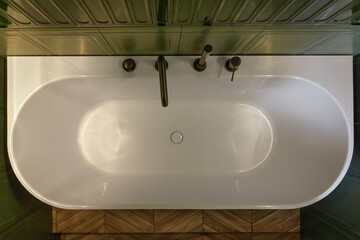 White bathtub top view amid green tiles. Top view.