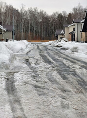 Spring thaw. Snow-covered, uncleared road in a siberian cottage village.