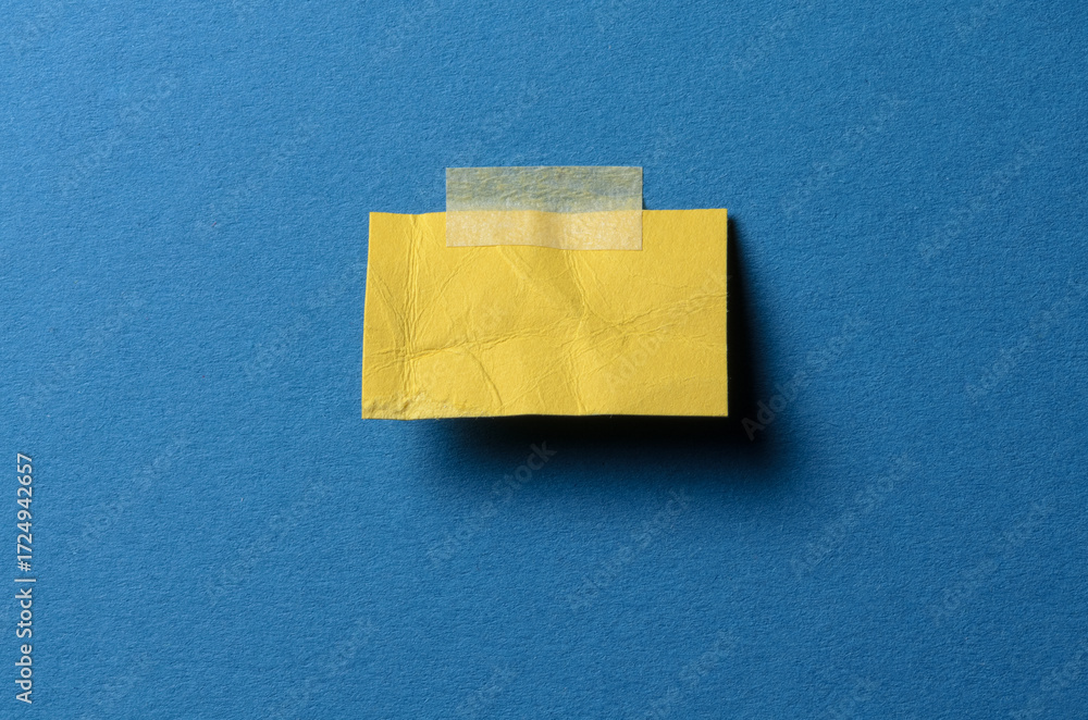 Poster cut out torn piece of blank yellow paper note with rough texture edges and adhesive tape with copy s
