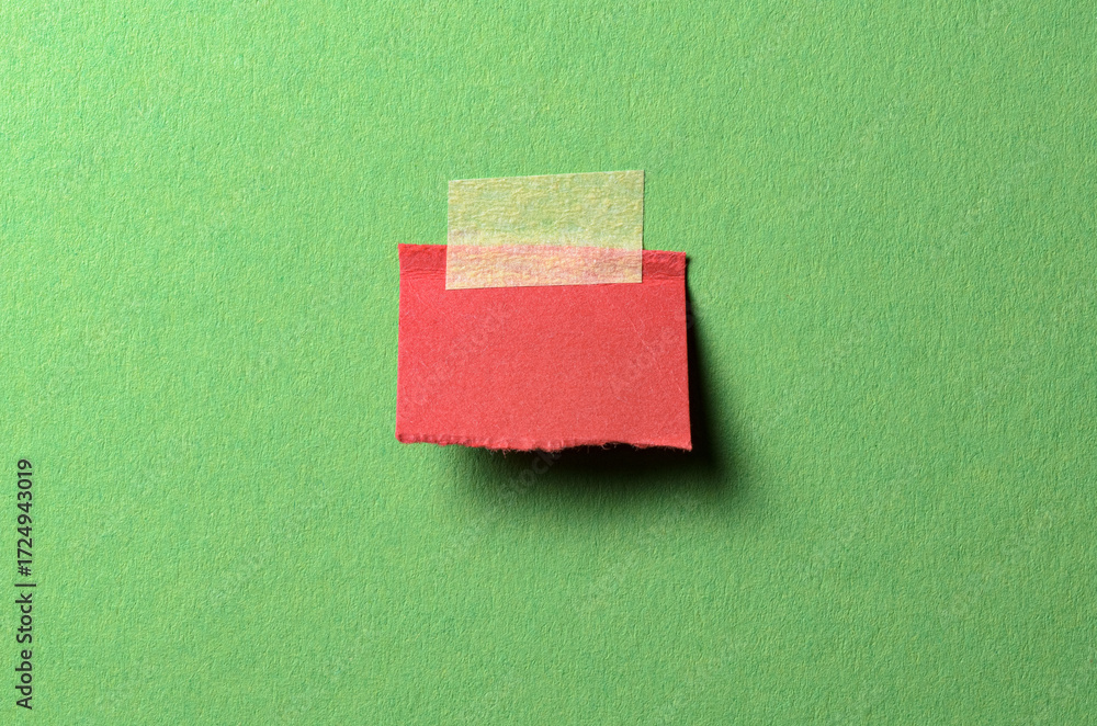 Poster cut out torn piece of red paper note with rough texture edges and adhesive tape with copy space for 