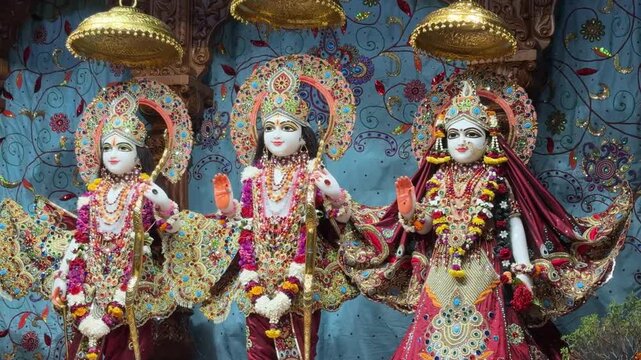 Lord Ram, Goddess Sita, and Lord Laxman dressed in traditional clothing with garlands, symbolizing Hindu mythology and devotion.