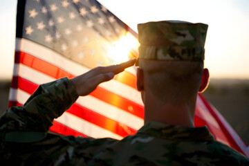 Patriotic Salute: A soldier salutes the American flag during sunrise, embodying the spirit of patriotism and devotion to country.