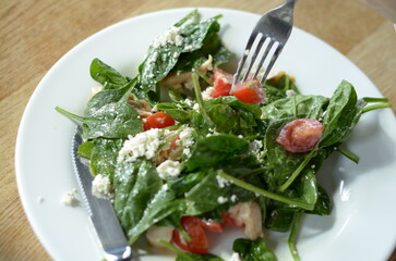 Salad with spinach, cherry tomatoes, cheese, and chicken