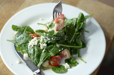 Salad with spinach, cherry tomatoes, cheese, and chicken