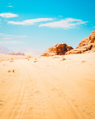 Scenic Wadi rum desert panorama in hot sunny day with car tracks on sand. Famous filming locations of movies like Star wars; the martian