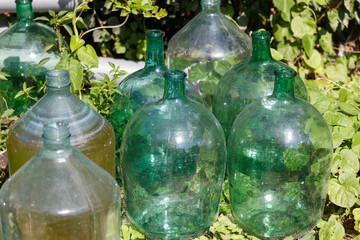 A bunch of green glass bottles are on the ground