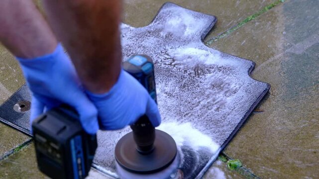 Cleaning a small car foot with a drill and brush attachment - close up