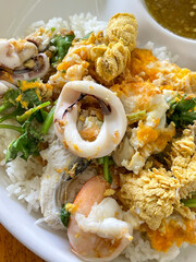 "Dried Rice Porridge seafood " Serve in a cup of cooked rice topped with cooked fish, shrimp and squid.