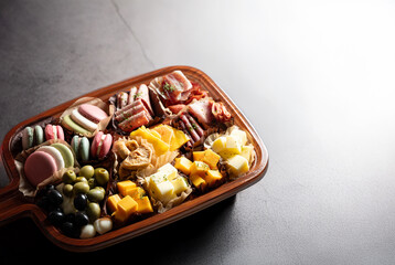 Raw ham, olives and cheese on a plate