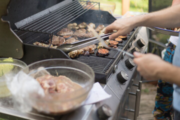 Meat sizzling on a gas grill captures the essence of grilling tradition. Smoky aroma, outdoor cooking, and shared meals. This culinary ritual brings people together.