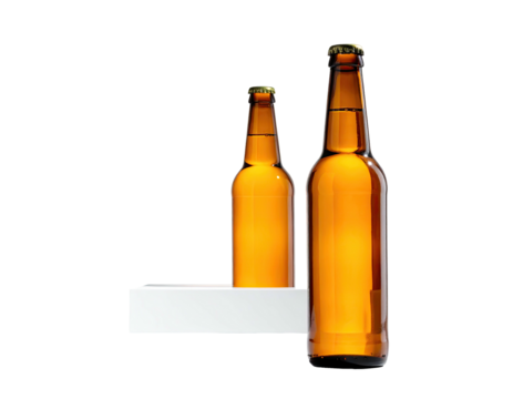 Two glass beer bottles, varying sizes, sit on a simple white shelf against a black backdrop