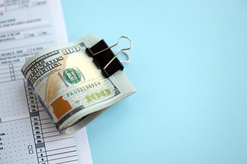 Big amount of United States dollar bills on table with tax return form close up