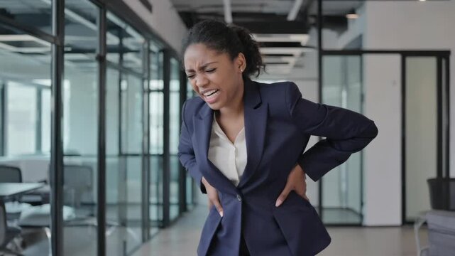 A woman wincing in pain, likely due to back discomfort.