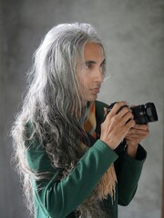 Man with long silver gray hair taking pictures