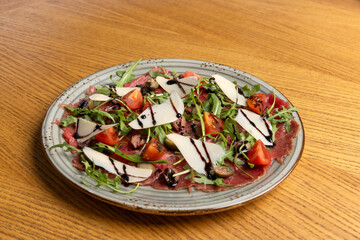 Carpaccio salad with arugula cherry tomato and parmesan cheese, top view