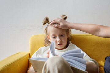 Mother measuring temperature of her ill child. Sick child with high fever and parent hand on kid forehead
