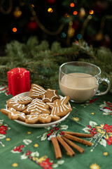 Christmas dessert with latte, gingerbread cookies, and candle