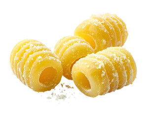 Close-up of several pasta shapes, light yellow, with ridges and holes, some sliced in half, scattered with a fine, light topping