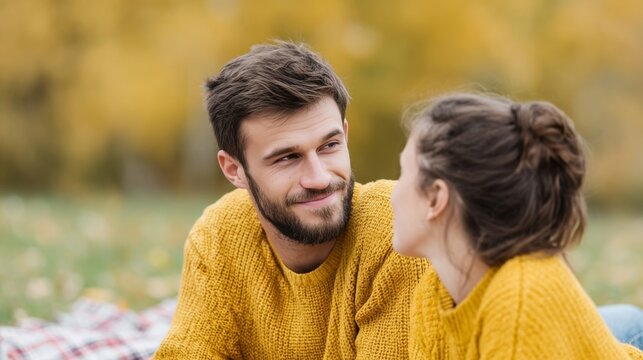 Couple in mustard sweaters sharing autumnal whispers, Evoking cozy harvest feelings during Dia de los Muertos' ethereal warmth
