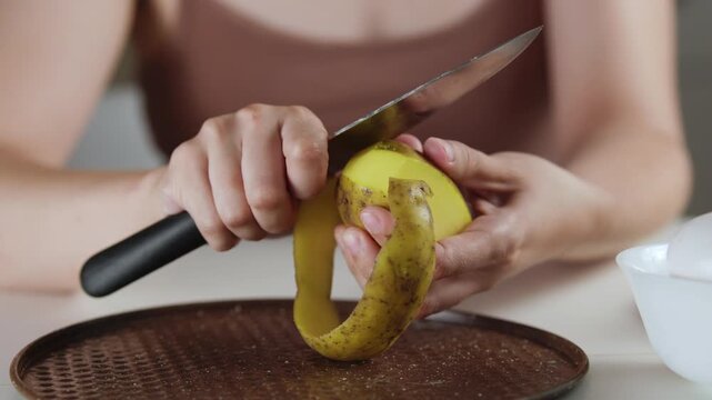 A chef professionally prepares a fresh vegetable salad, chopping potatoes, eggs, and greens. Dynamic cooking process showcasing culinary skills and healthy food preparation
