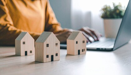 Woman Working on Laptop with Miniature Wooden Houses Real Estate Agent Home Ownership.