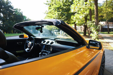 Fototapeta premium Modern cabriolet parked on parking lot outdoors, closeup