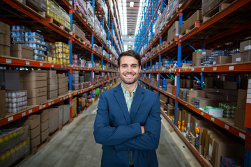 Shelving units extending high and holding rows of stacked cardboard boxes in bright warehouse aisle