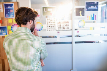 Glass partition showing color wheels and data charts in modern design studio under bright lighting