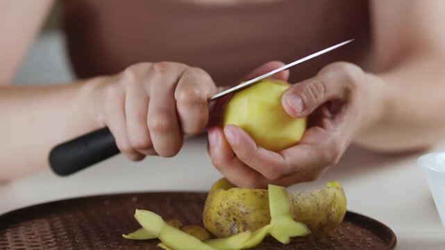 A chef professionally prepares a fresh vegetable salad, chopping potatoes, eggs, and greens. Dynamic cooking process showcasing culinary skills and healthy food preparation
