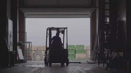 Forklift moves large wooden crates filled with fresh apples at an agricultural cold storage facility. Massive stacks of crates indicate fruit harvest logistics and post-harvest handling operations. - Powered by Adobe