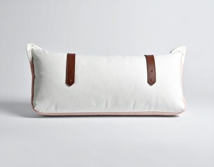 Long rectangular off-white bolster pillow with blush pink edges and brown leather straps