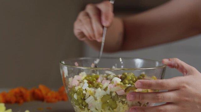 A chef professionally prepares a fresh vegetable salad, chopping potatoes, eggs, and greens. Dynamic cooking process showcasing culinary skills and healthy food preparation
