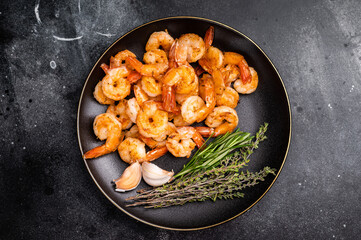 Appetizing grilled shrimp prawns served on a platter, perfect for elegant dinners or casual gatherings with friends. black background. top view
