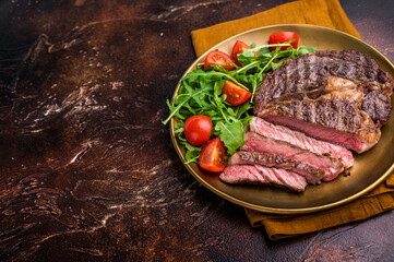 Dinner with Grilled Rib eye steak, fried dry aged beef meat. brown background. top view