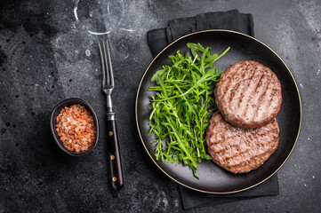 Grilled beef and pork meat patty paired with fresh veggies, an essential component for gourmet burgers. black background. top view