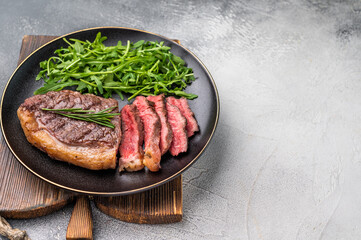 Tender grilled striploin New York steak paired with fresh vegetables, the ultimate comfort food for any occasion. white background. top view