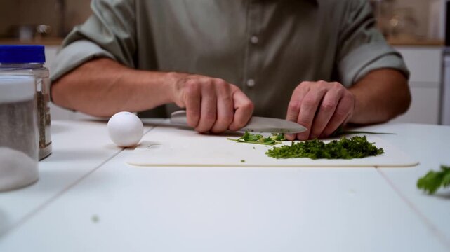 A chef professionally prepares a fresh vegetable salad, chopping potatoes, eggs, and greens. Dynamic cooking process showcasing culinary skills and healthy food preparation
