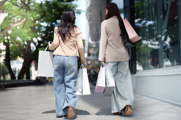 Fototapeta premium Black Friday shopping: Friends walking with colorful bags