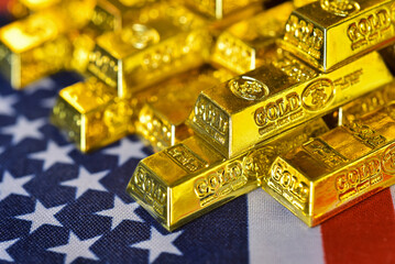 Stacking gold bars on US flag and golden lightbackground. Gold is hard commodity goods, risk asset, tangible value that used to be gold reserve, save assets during war and economic crisis