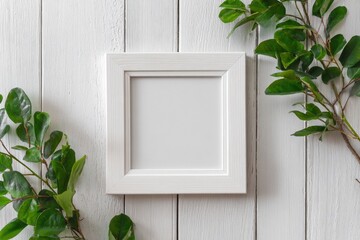 Empty white square frame, flanked by greenery on a white wooden background